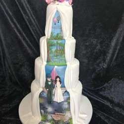 back of pink rose draping down wedding cake with bristol ballons and sailing couple